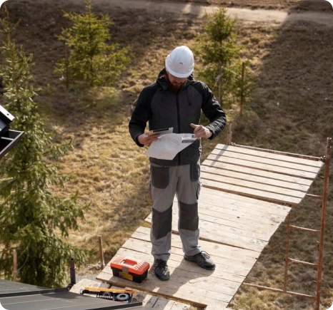 Instalación de Onduline Bajo Teja 10 Trabajador de construcción con casco revisando planos en una obra al aire libre.