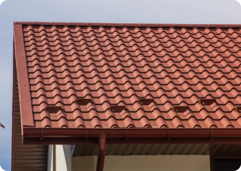 Contrucción de tejados 2 Tejado con tejas cerámicas terracota y canalones instalados en vivienda.